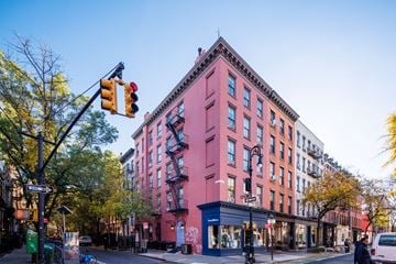 New York apartment for rent - a pink building on the corner of a street with a traffic light