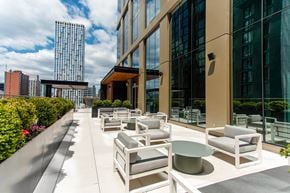 Brooklyn apartment for rent - A patio with white furniture and a building in the background.