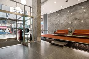 New York apartment for rent - A glass door with a red trash can in front of it.