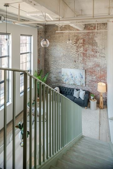 St. Louis apartment for rent - a living room with a brick wall and a couch and a staircase