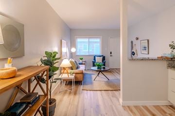 St. Louis apartment for rent - a living room with white walls and wooden floors and a dining room table