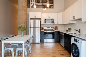 St Louis apartment for rent - a kitchen with white cabinets and black and white appliances at The Draper, Missouri