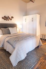 St Louis apartment for rent - a bedroom with a large bed and a white wardrobe at The Draper, Missouri