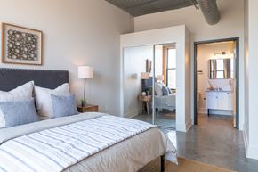 St. Louis apartment for rent - a bedroom with a large bed and a bathroom in the background