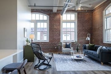 St. Louis apartment for rent - a living room with a brick wall and a couch and a chair
