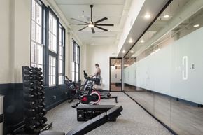 St. Louis apartment for rent - a man running on a treadmill in a gym with weights and other exercise equipment