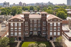 St. Louis apartment for rent - a large brick building with a city in the background