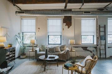 St. Louis apartment for rent - A living room with a couch, chairs, and a table with a book on it.