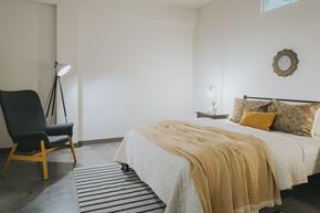 St. Louis apartment for rent - A bedroom with a bed, chair, and lamp.