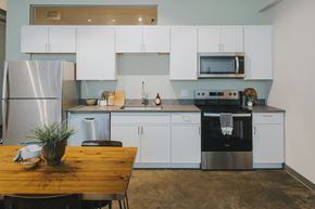 St. Louis apartment for rent - A kitchen with white cabinets and a wooden table.