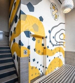 A building with a yellow and white mural on the side of it