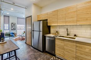 St. Louis apartment for rent - A kitchen with a refrigerator, sink, and wooden cabinets.