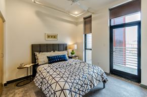 St. Louis apartment for rent - A bedroom with a patterned bedspread and a ceiling fan.