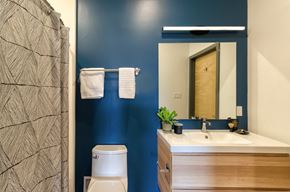 St. Louis apartment for rent - A bathroom with a blue wall and a wooden vanity.