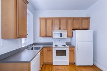 Saint Louis apartment for rent - A kitchen with wooden cabinets and white appliances.