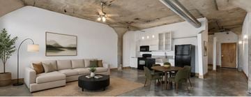 St. Louis apartment for rent - A living room with a couch, a table, and a painting on the wall.