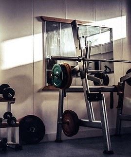 A gym with weights and a mirror on the wall