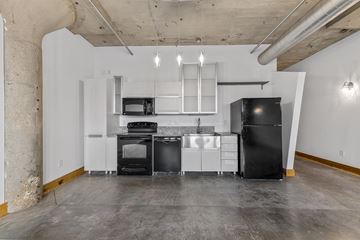 St. Louis apartment for rent - A kitchen with black appliances and white cabinetry.