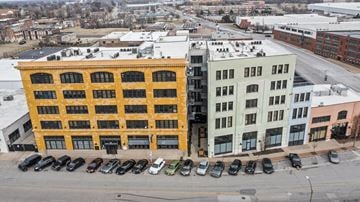 St. Louis apartment for rent - A yellow building is in the middle of a parking lot.
