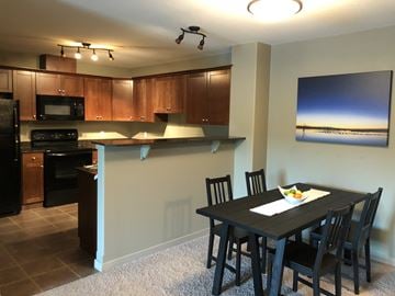 Ft Mcmurray apartment for rent - A modern kitchen with a dining table set for two.