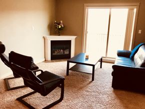 Ft Mcmurray apartment for rent - A living room with a fireplace and a chair.