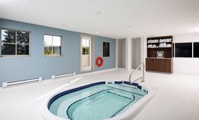 Ft Mcmurray apartment for rent - a whirlpool tub in the center of a large room with a blue wall