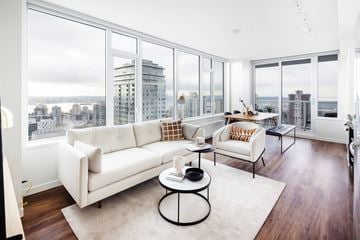 North Vancouver apartment for rent - A white couch sits in a living room with a view of the city.