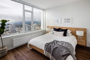 North Vancouver apartment for rent - A bedroom with a large bed and a view of the city.