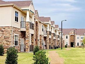 Thackerville apartment for rent - A row of houses with a pathway in the foreground.