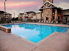 Thackerville apartment for rent - A swimming pool surrounded by a stone wall and lounge chairs.