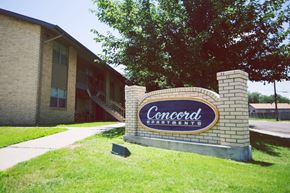 Amarillo apartment for rent - a sign for concord apartments in front of a brick building