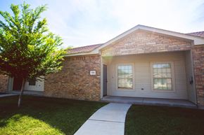 Amarillo apartment for rent - the front of a brick house with a sidewalk and grass