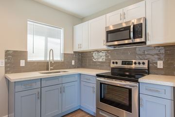 Phoenix apartment for rent - A kitchen with a stove top oven and microwave above it.