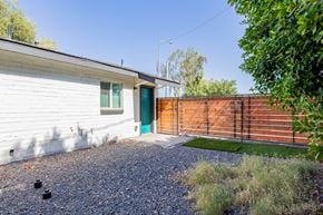 Phoenix apartment for rent - a small white house with a blue door and a wooden fence