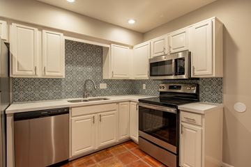 Phoenix apartment for rent - A kitchen with white cabinets and a tile backsplash.