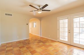 Phoenix apartment for rent - an empty living room with a ceiling fan and french doors
