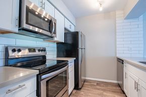 Tempe apartment for rent - a kitchen with white cabinets and stainless steel appliances