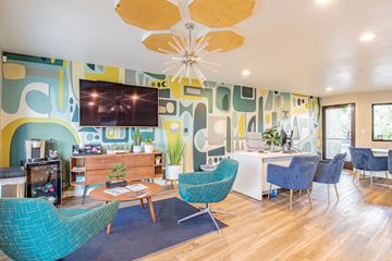 Tempe apartment for rent - a living room with blue chairs and a table and a television