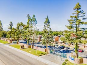 Bakersfield apartment for rent - a view of a parking lot with trees and buildings