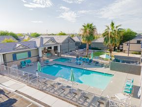 Peoria apartment for rent - our apartments have a swimming pool with chairs and palm trees at Villas on Olive, Peoria, Arizona