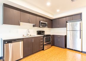 Tempe apartment for rent - an empty kitchen with stainless steel appliances and wooden floors