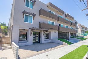 Panorama City apartment for rent - a view of the front of a building with a sidewalk and grass
