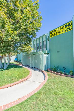 Panorama City apartment for rent - a sidewalk in front of a building with a sign for now renting