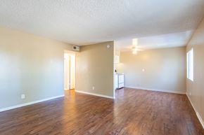 Bakersfield apartment for rent - an empty living room with wood flooring and a kitchen