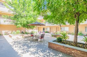 Sherman Oaks apartment for rent - A patio with a table and chairs under a tree.