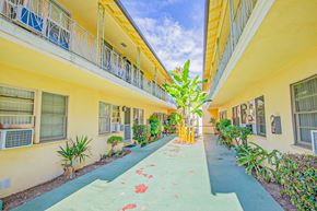 Sherman Oaks apartment for rent - a courtyard between two yellow buildings with a blue walkway