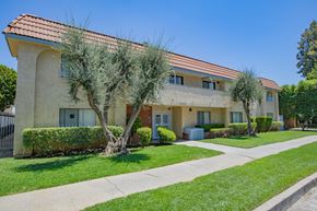 Canoga Park apartment for rent - A building with a red roof and a tree in front of it.