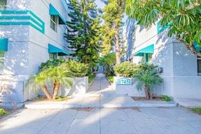 Long Beach apartment for rent - a sidewalk in front of a building with palm trees