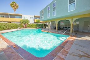 Reseda apartment for rent - a swimming pool in front of a building with a resort style pool