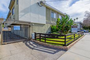 Valley Village apartment for rent - an apartment building with a fence and a sidewalk in front of it